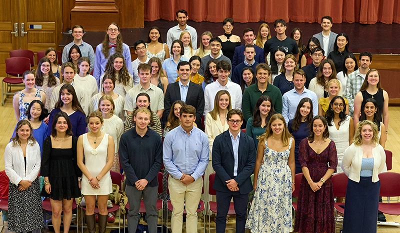 A group of 64 students stand for a group photo.