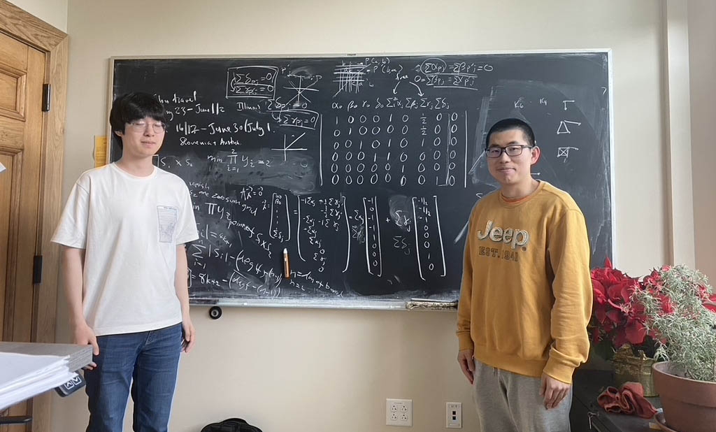 Students Seunghwan Oh and Xianzhi Wang at chalkboard
