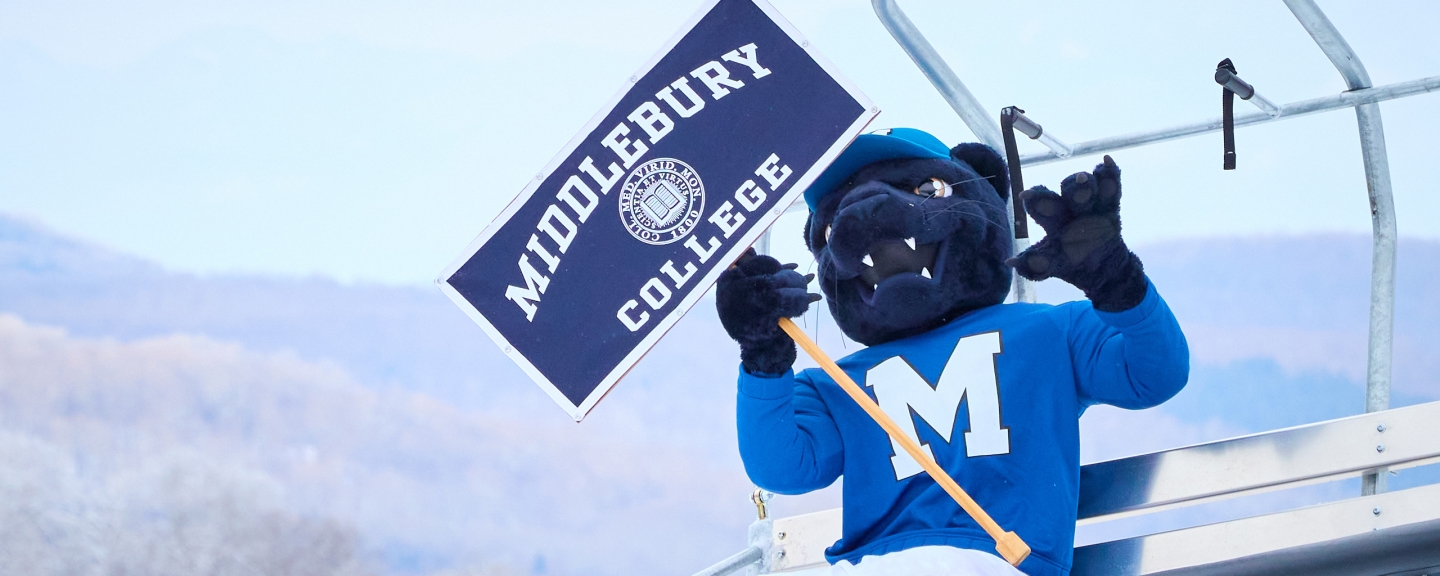The Middlebury panther mascot riding up the chair lift at the Middlebury Snow Bowl