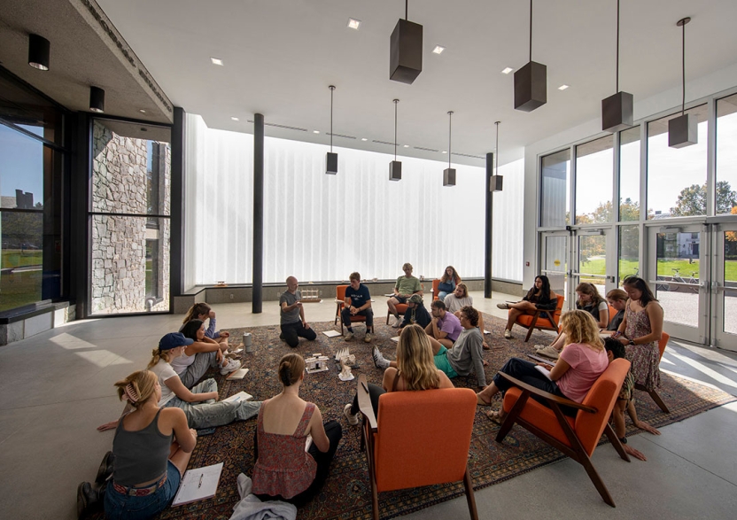 A class is gathered in the bright naturally lit pavilion.