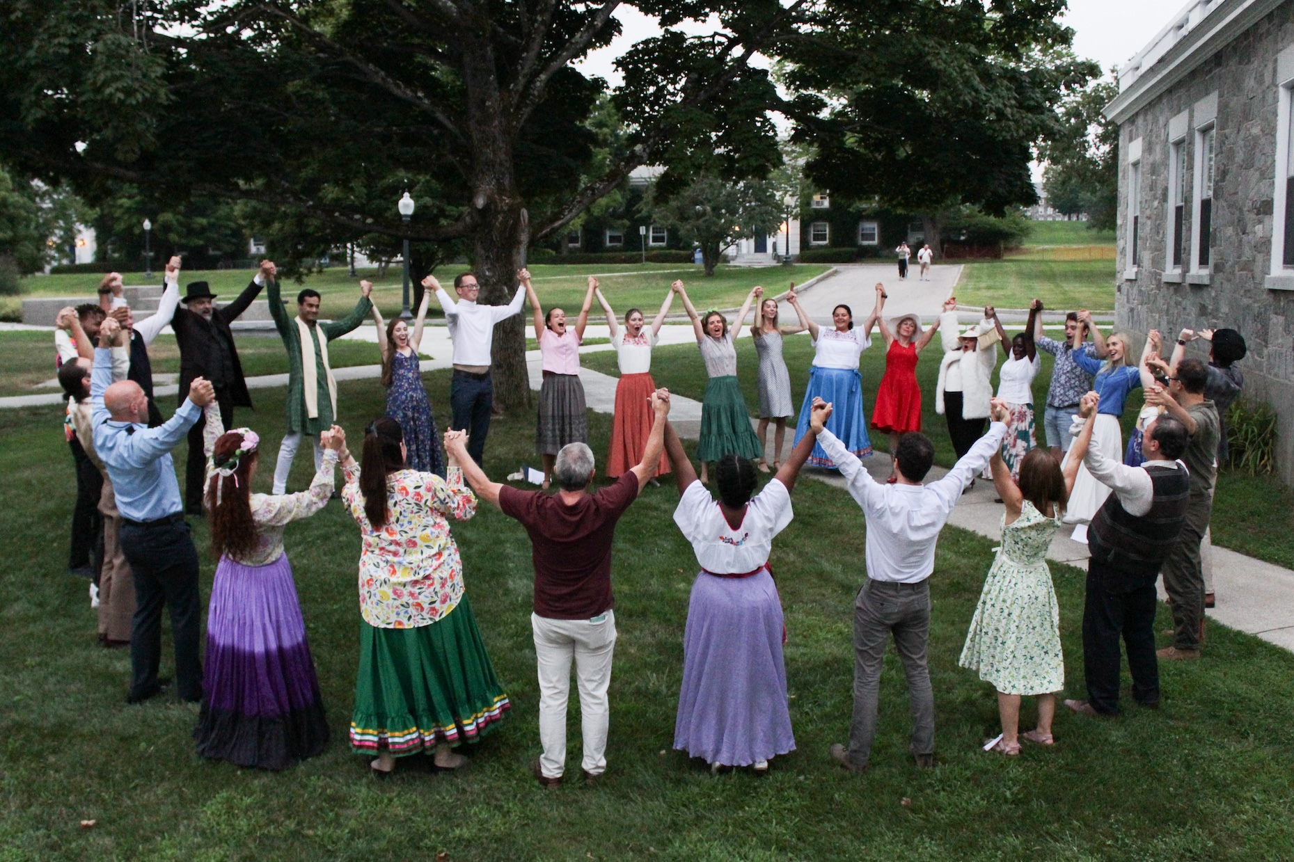 A group of students hold hands in a circle.
