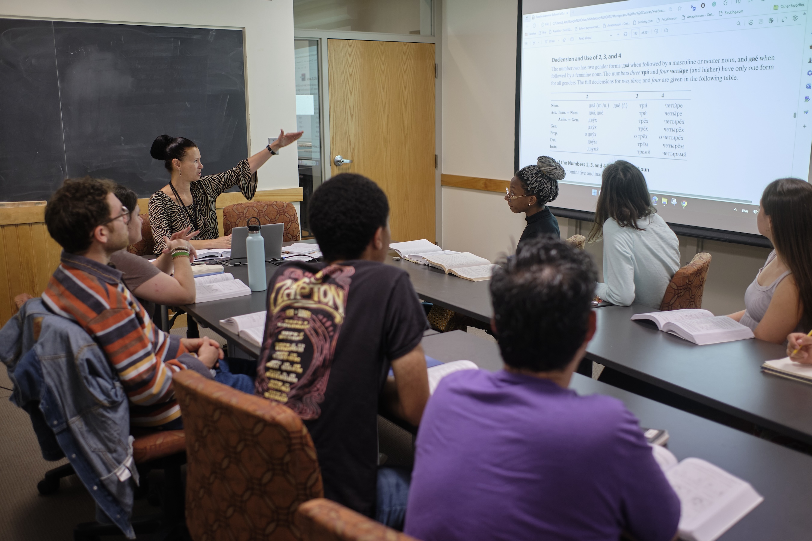 Students look at a screen with their teacher in class.