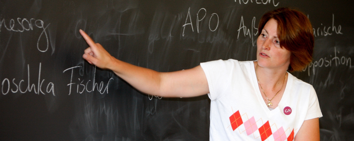 A German professor pointing to words on a chalkboard.