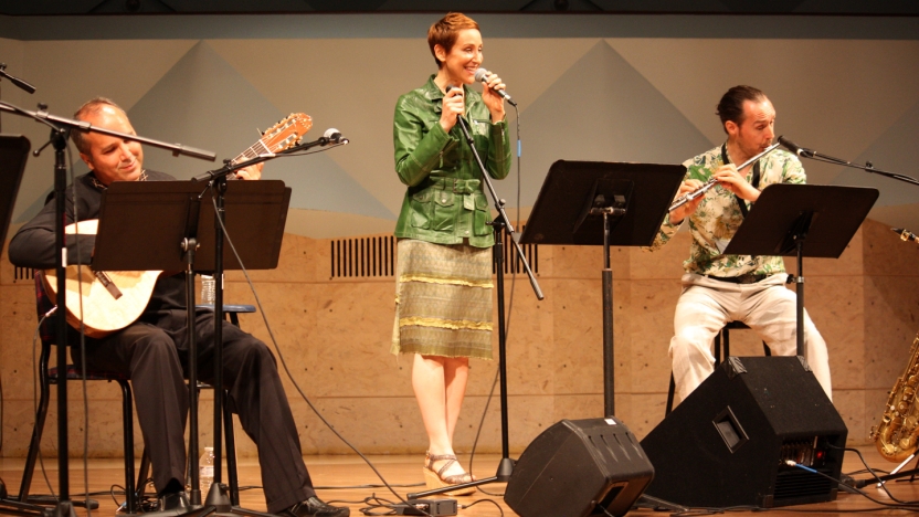Two male Portuguese language students play instruments while a female student sings.