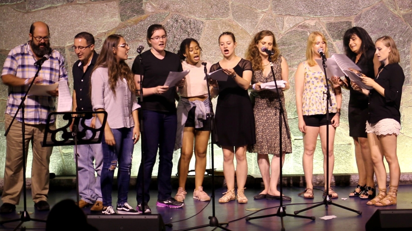 Ten Portuguese students sing together on stage.