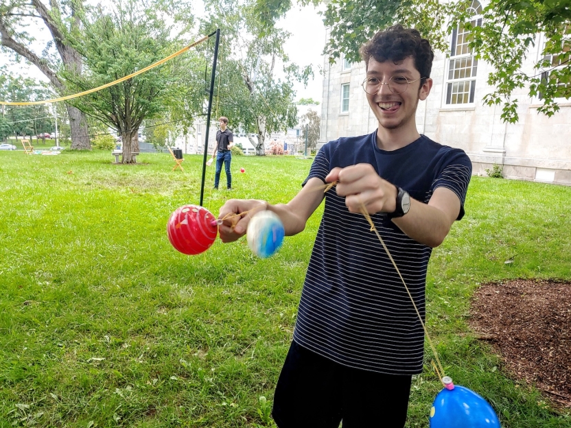 A student swings around colorful water balloons.