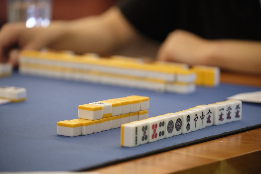 yellow black and white tiles with Japanese lettering on them are stacked up on a table for a game. 