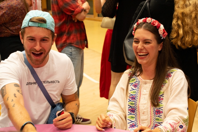 Two students laugh at a table.