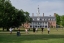Students play soccer outside in the grass.