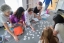 Students work with paper slips together at a table in class.