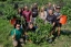 Students stand in the garden, smiling with their plants.