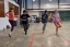 Students perform a dance, holding hands.