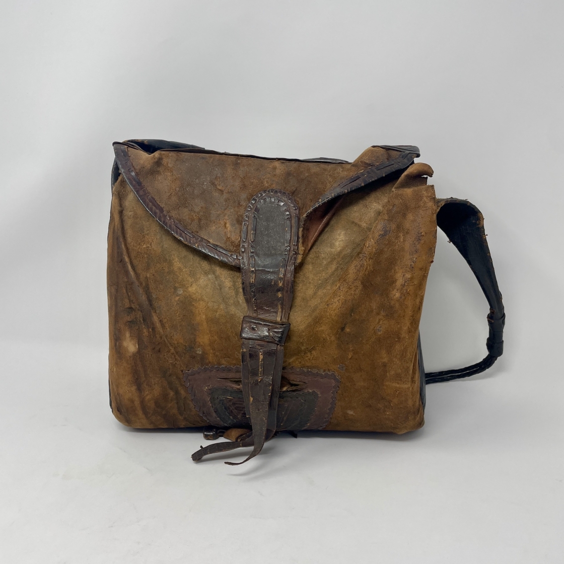 brown leather saddlebag with flap and strap