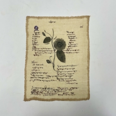 woven and embroidered page with illegible text and image of a flower