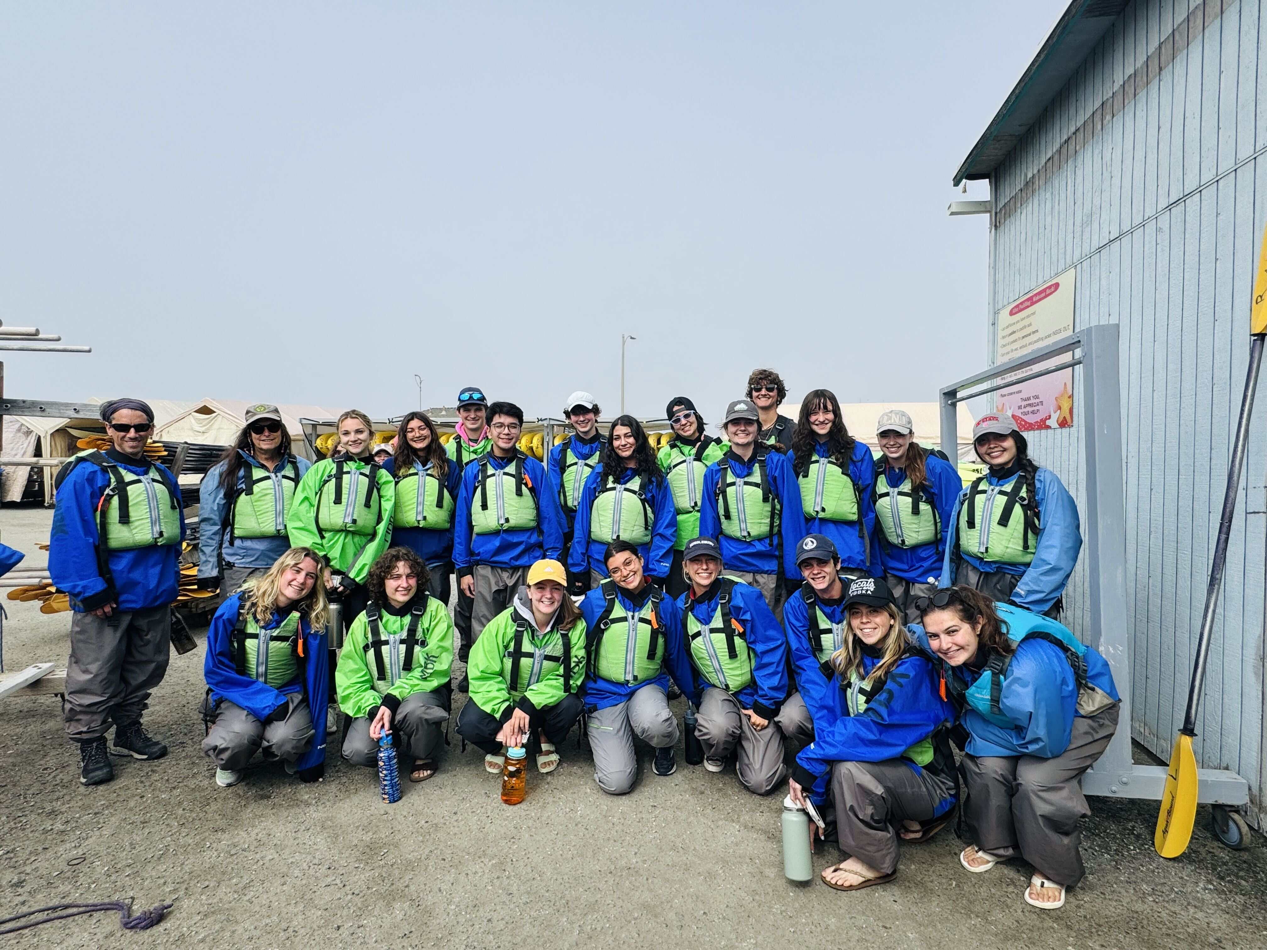 A group of students wearing green lifejackets