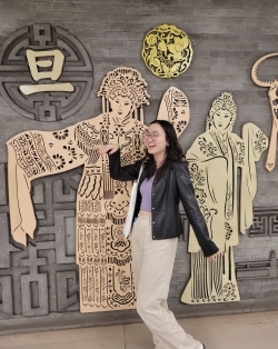 Student posing in front of a mural