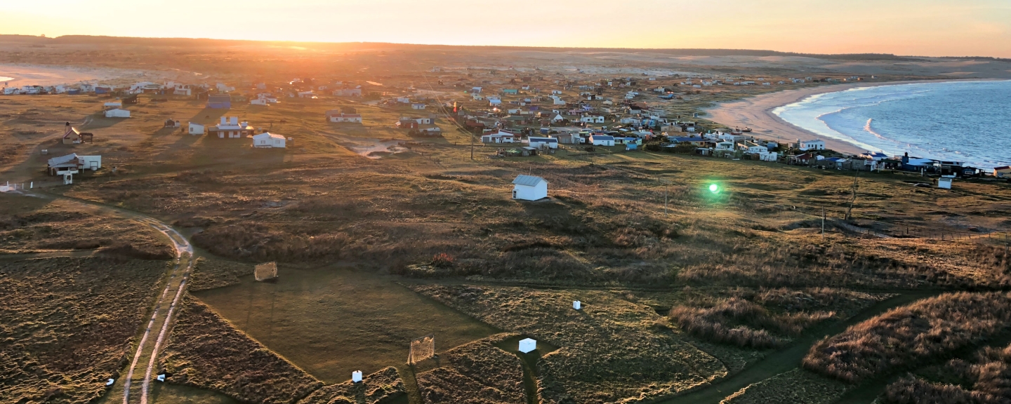 Homes near the beach with setting sun in background