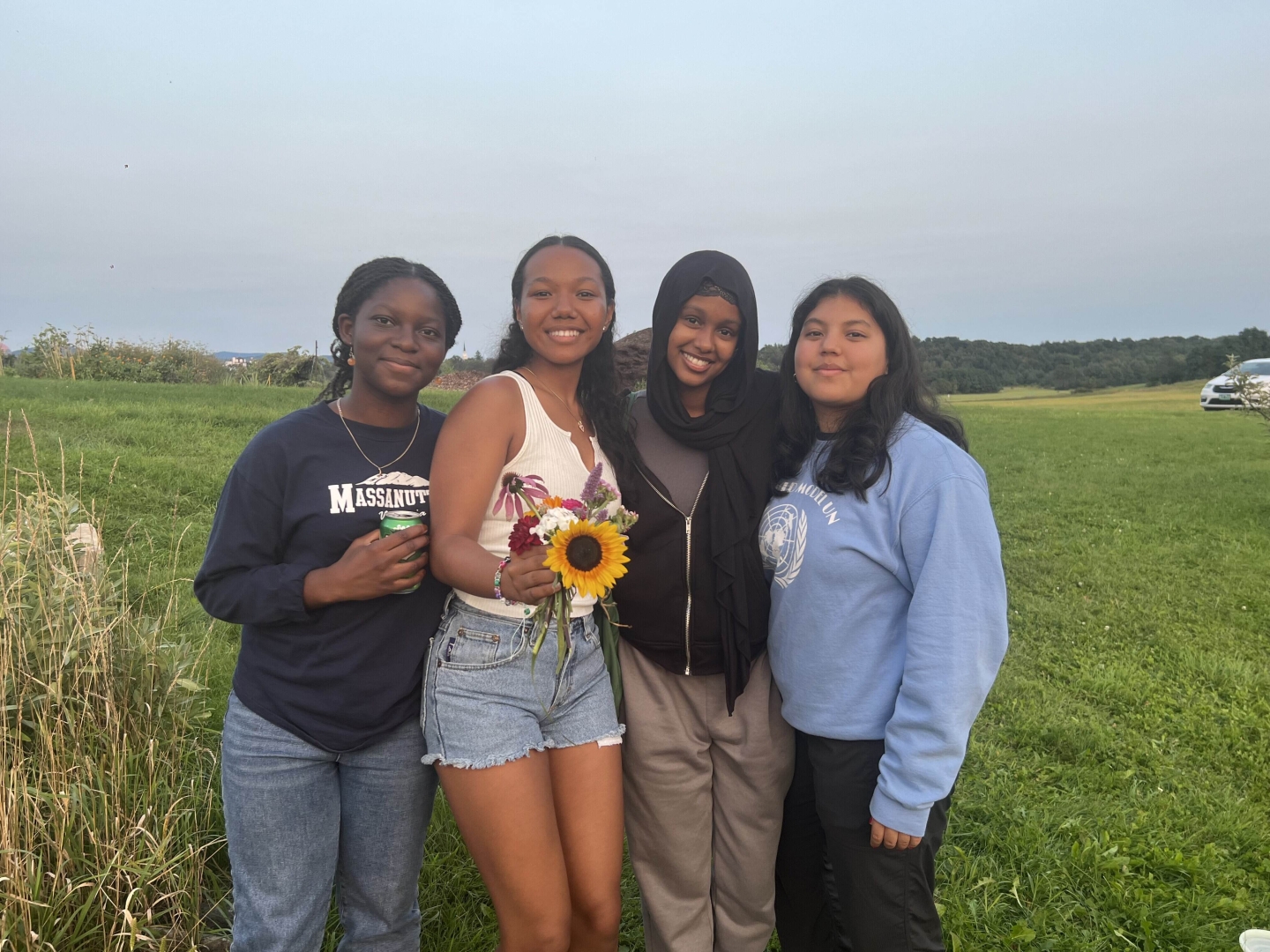 Four students standing in a field