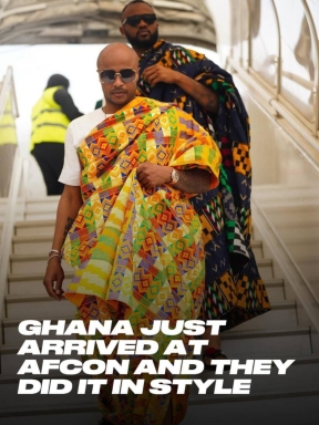 A photo of two black men in colorful African attire, walking down stairs. It is a screenshot of a social media post and reads, "Ghana just arrived at Afcon and they did it in style."