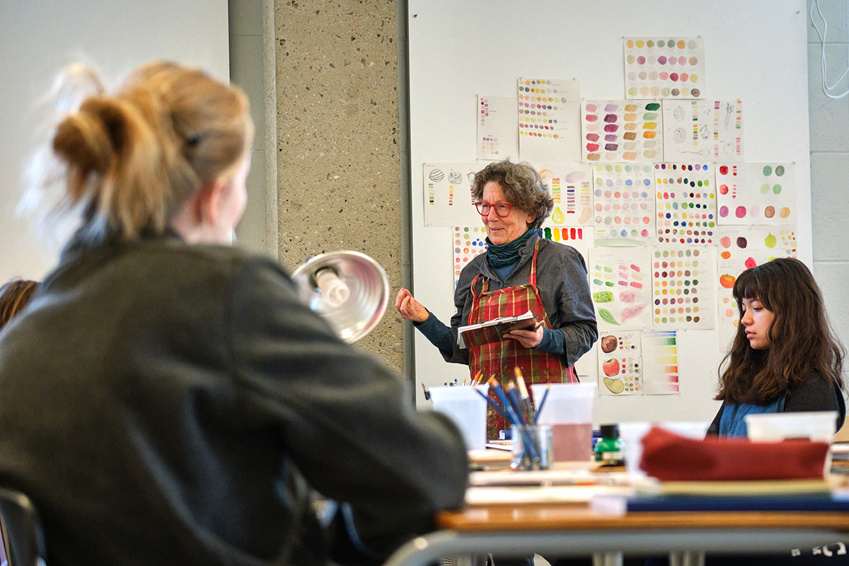 An art instructor speaks to students in a class on illustration.