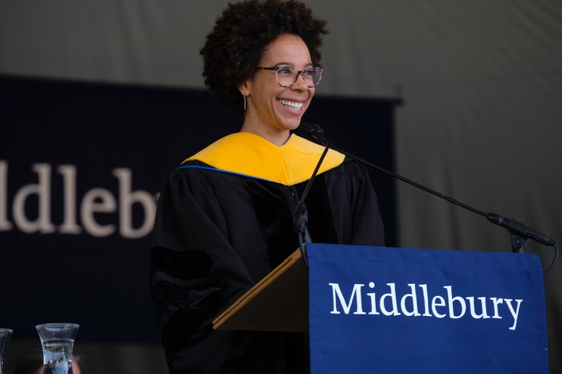 Speaker Ayana Johnson in commencement robes speaking at podium