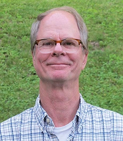 Photo of man smiling outdoors.