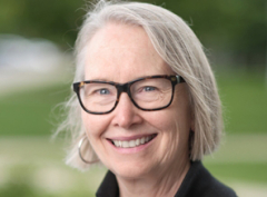 Head shot of a woman smiling with glasses.