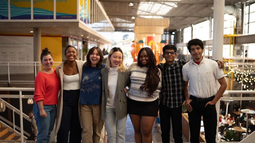 Student interns line up for a photo in an open office building.