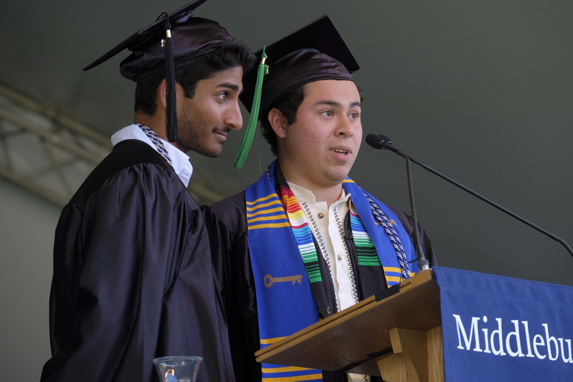 Two Middlebury College graduates standing at a podium to deliver the Commencement student address.