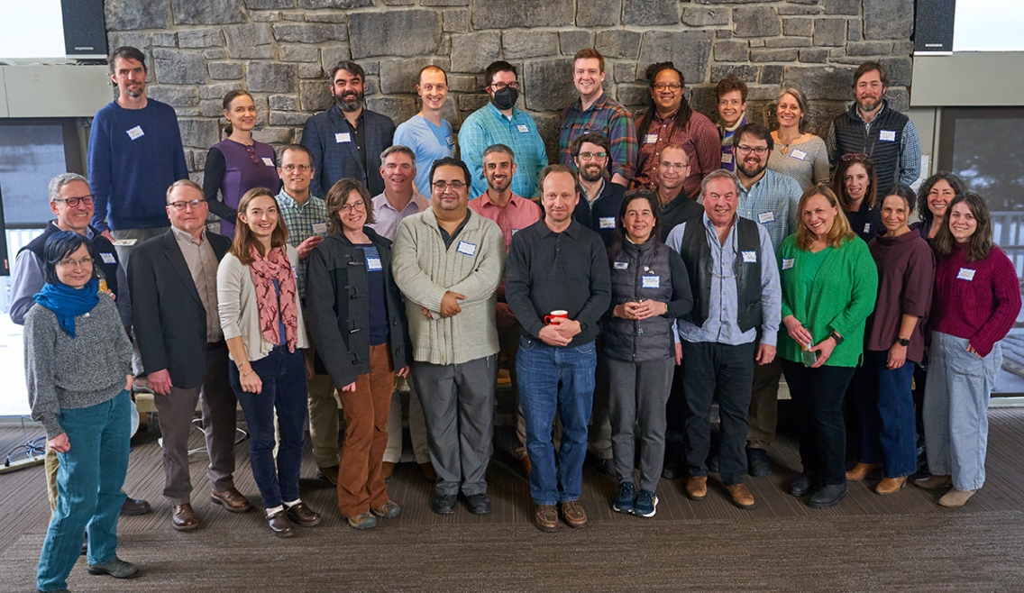 A group of Middlebury faculty and staff pose for a photo at the Kirk Alumni Center.