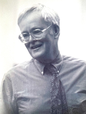 Photo of John McWilliams smiling away from the camera.