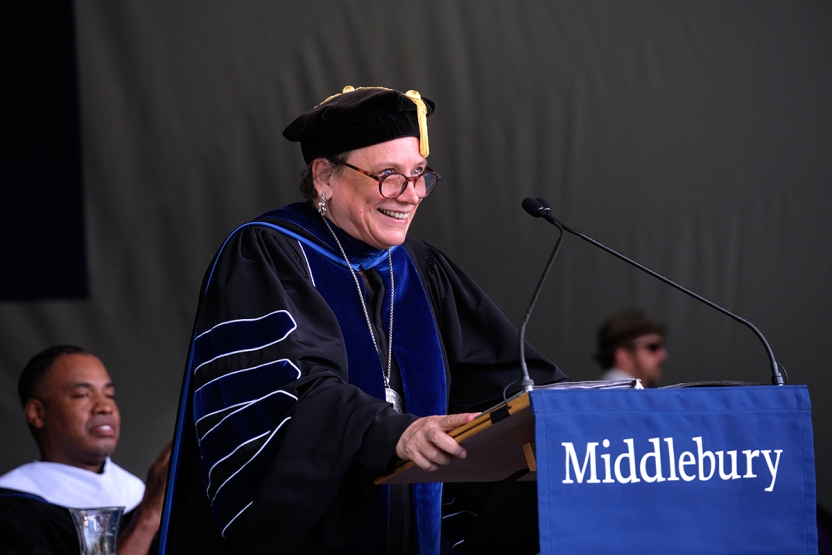 At college commencement, president in academic regalia stands at the podium.