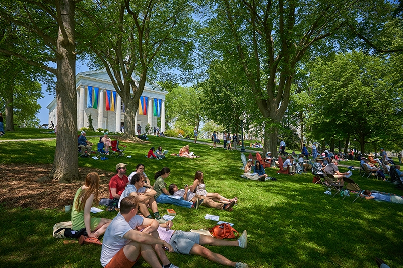 Audience sitting under trees enjoys commencement at Middlebury College