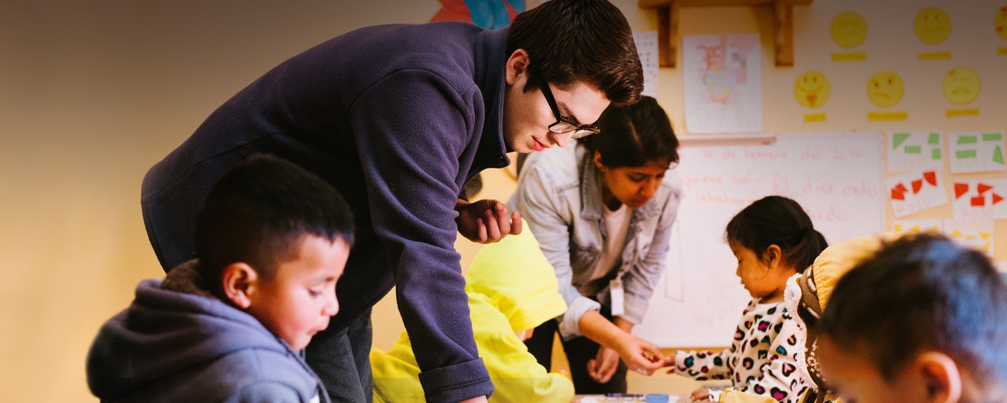 Student working in a classroom with younger students while studying abroad.