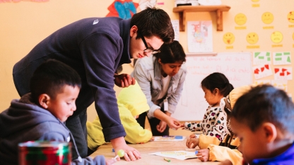 Student working in a classroom with younger students while studying abroad.