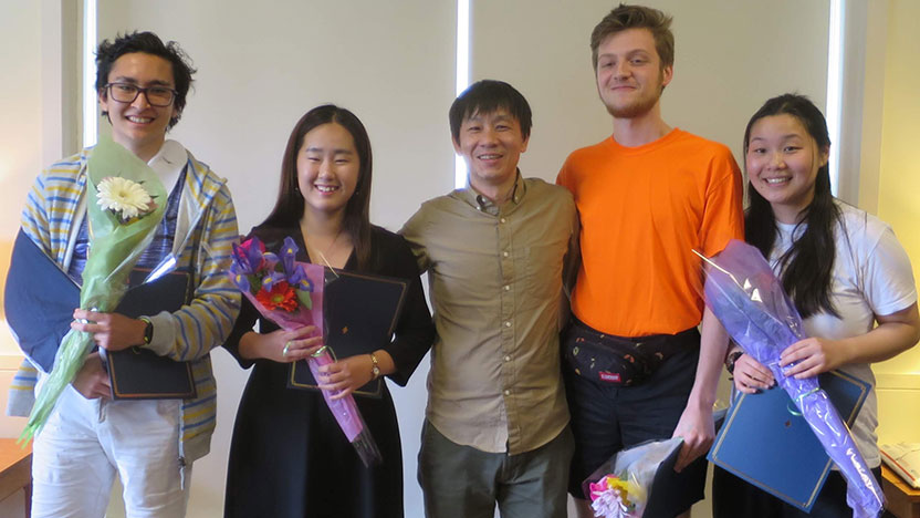 Five students pose holding flowers after doing well at the speech contest