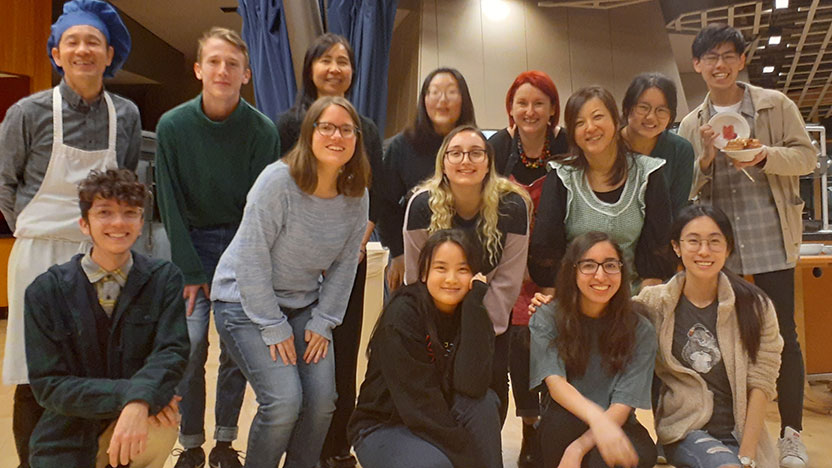 Students and sushi chefs pose for a photo after learning to make sushi