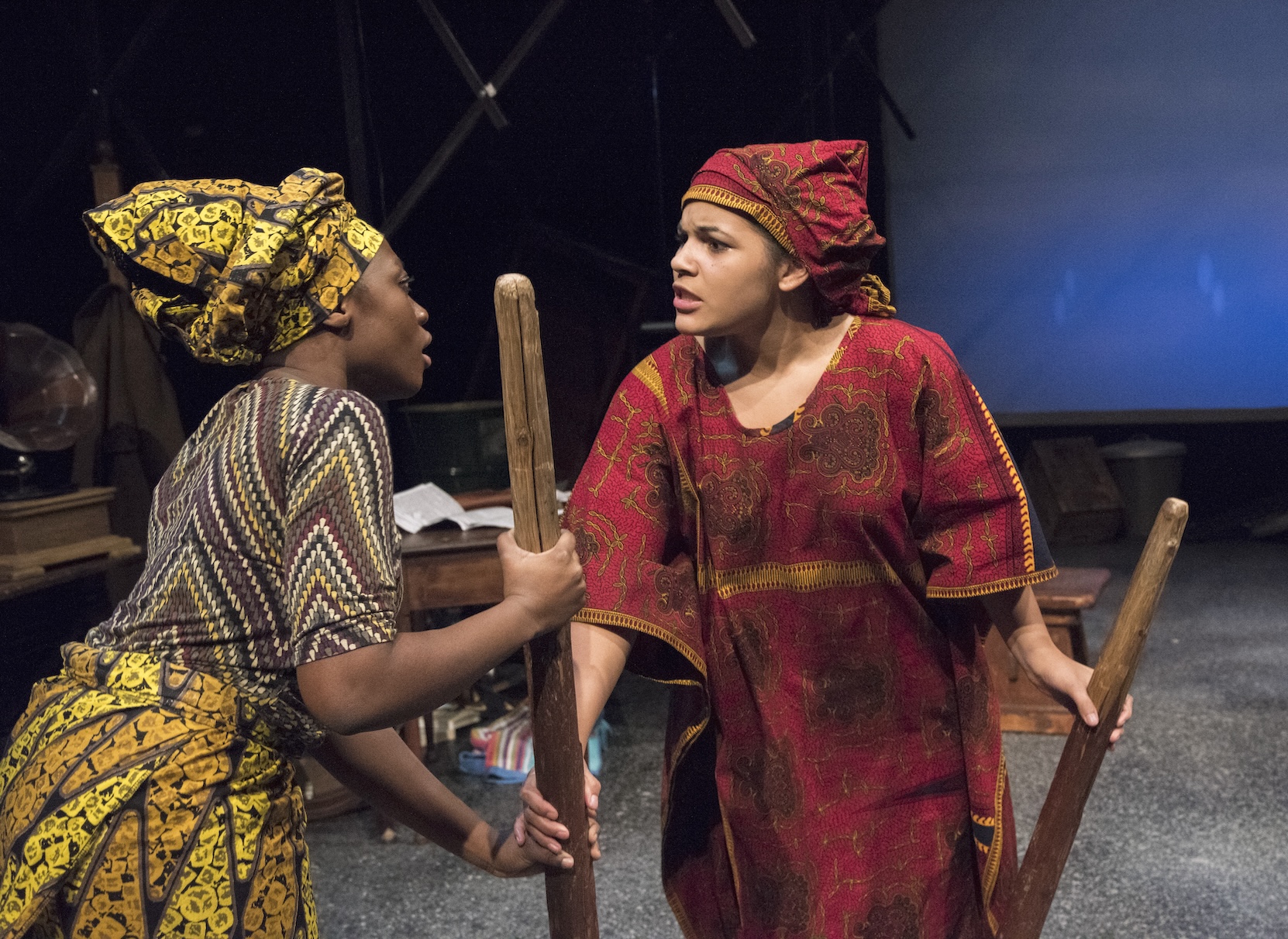 Two actresses arguing with each other, holding brooms