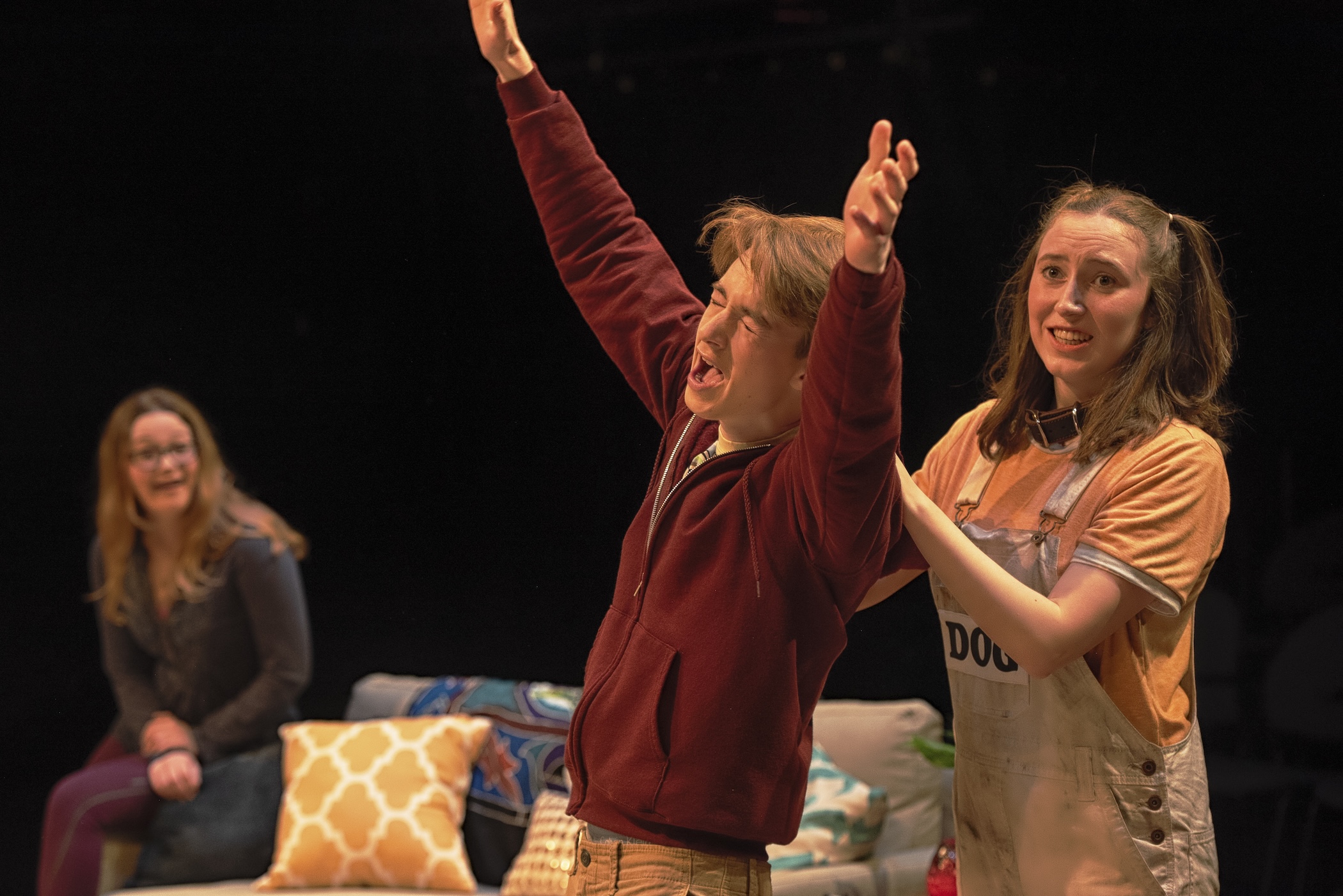 man with hands in the air and girl with hands on his shoulders