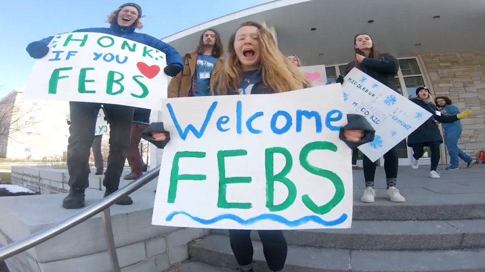 Students holding welcome signs for arriving Feb students.