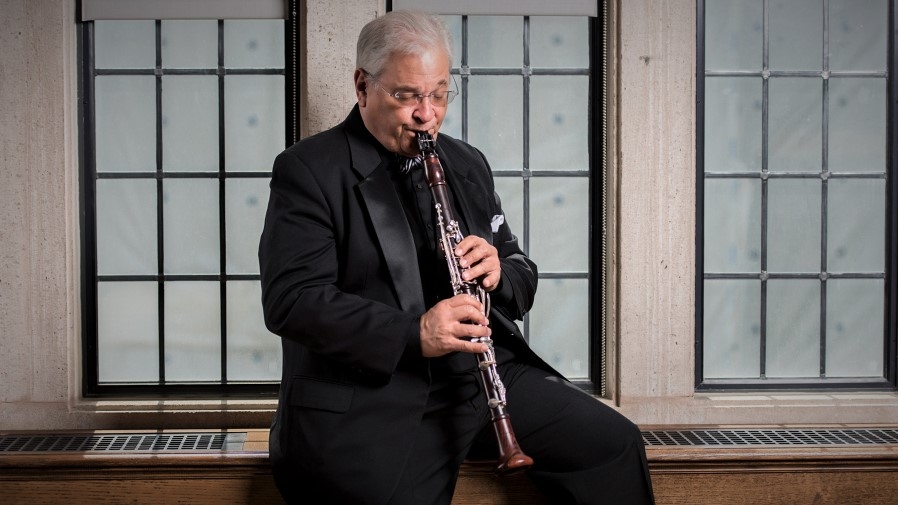 a man in black and grey playing a clarinet
