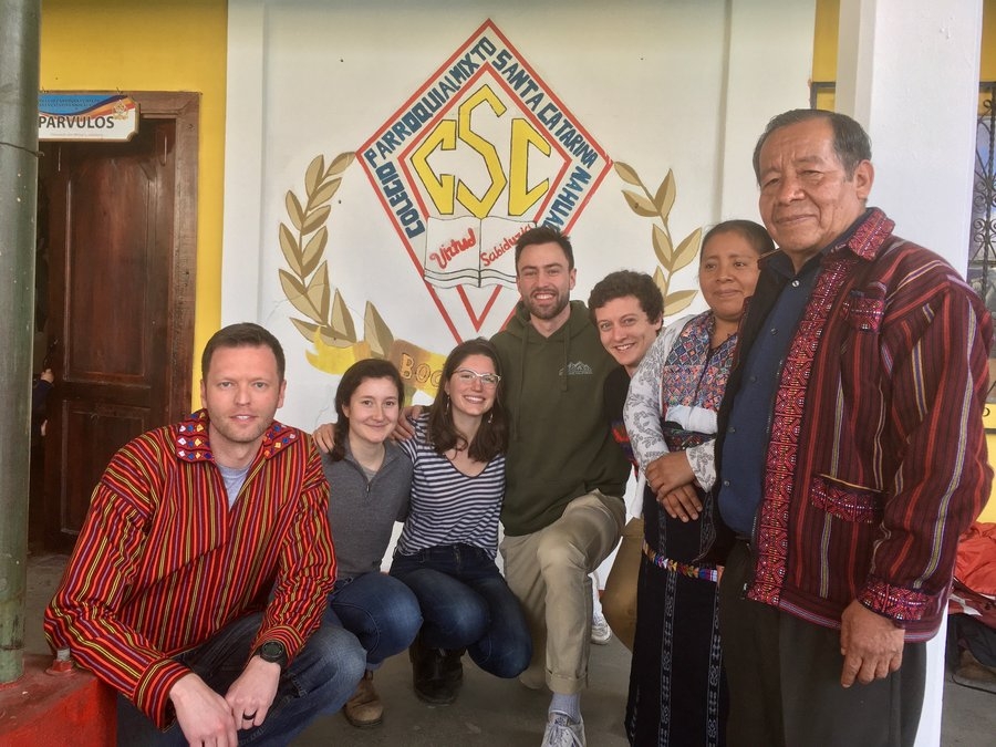 Seven people standing in front of a school in Guatemala