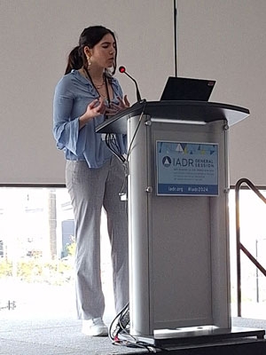 Myrto Ziogas delivers a speech at a podium.