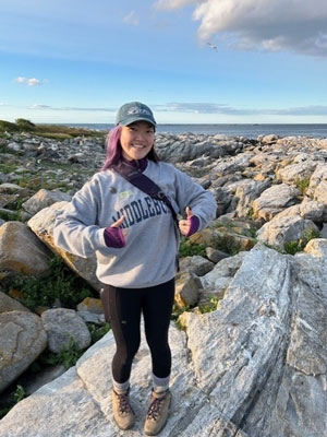 Student on the rocks along the maine coastline.