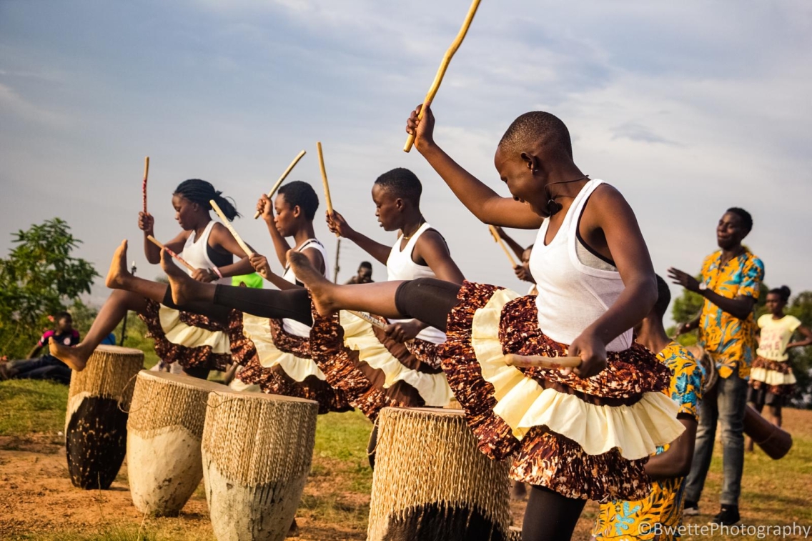 A group dances and plays drums