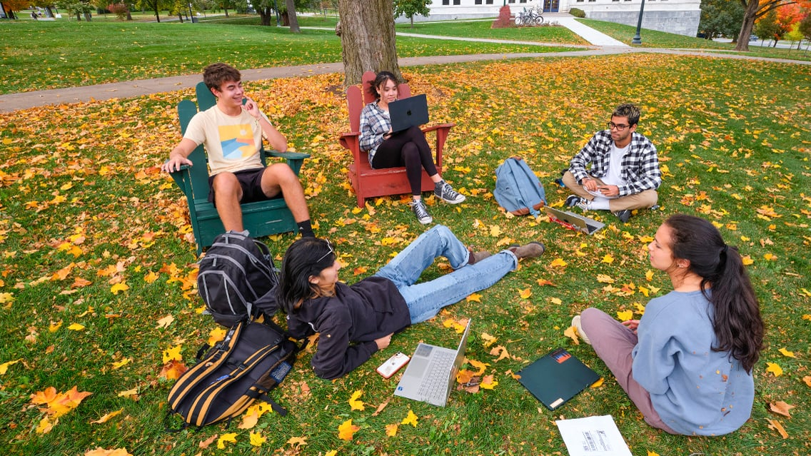 Students sitting outside hanging out on campus.