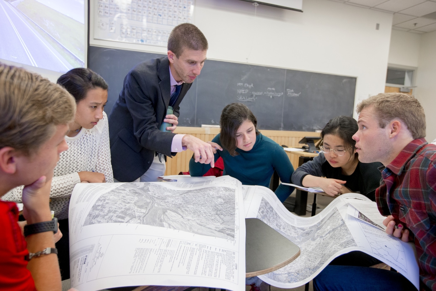 Students and professors sitting and working in a class.