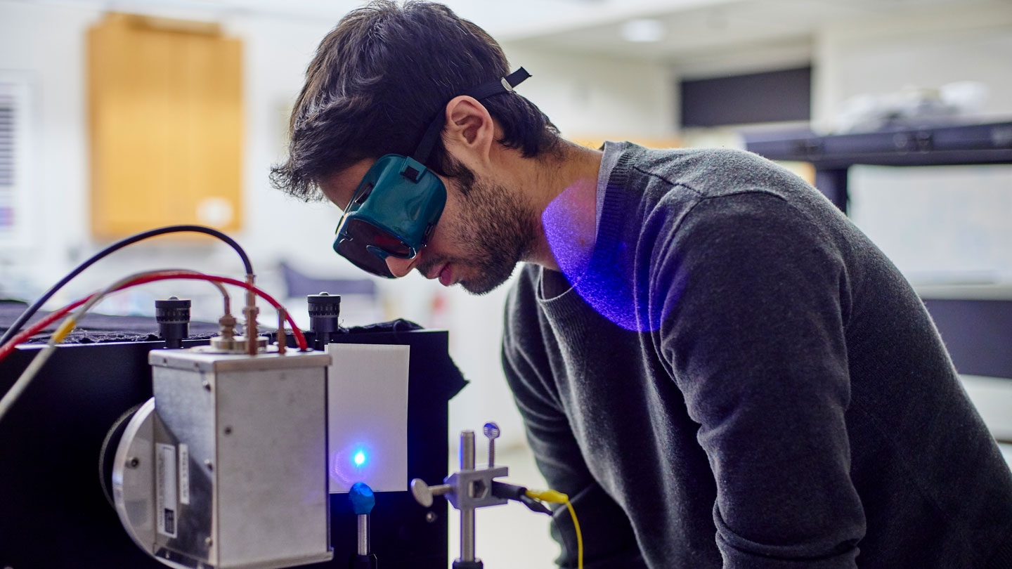 Student working with instruments in a physics lab.