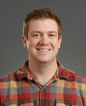 person with short hair in plaid shirt- fall colors