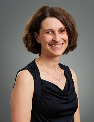 Woman in black sleeveless top, medium brown hair.